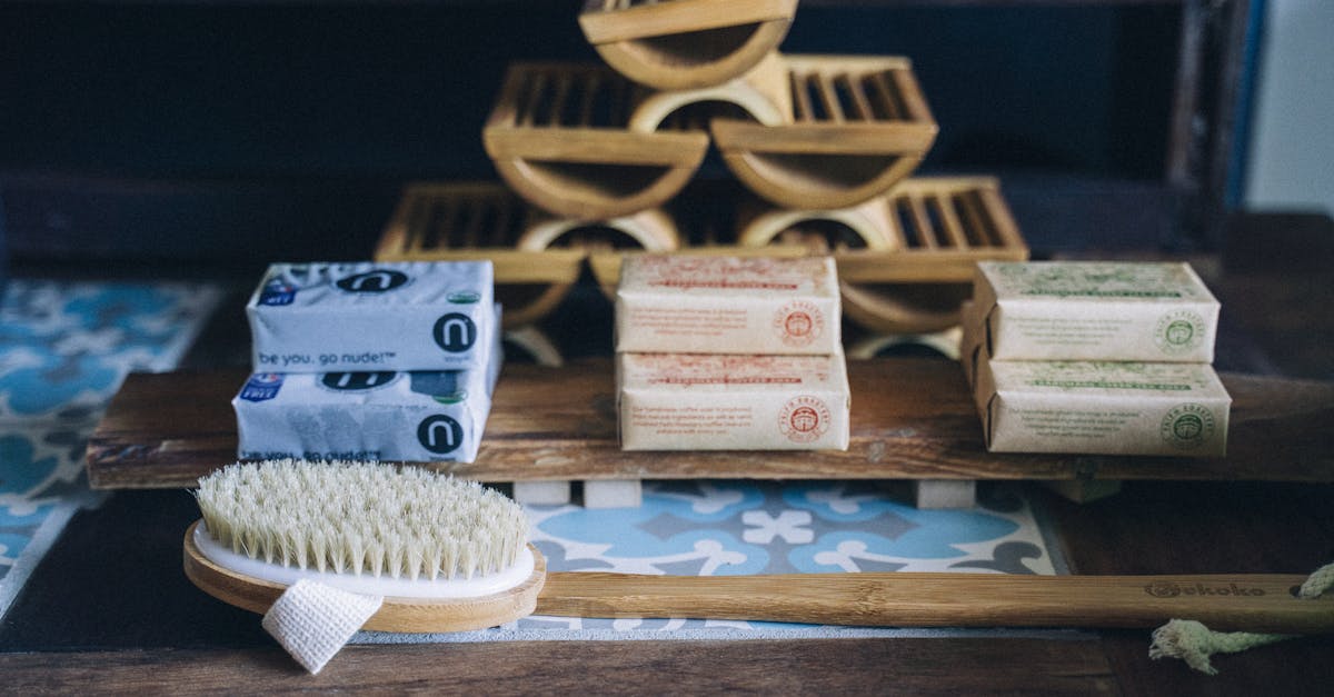 A close-up of a bamboo brush with handmade eco-friendly soap bars on a wooden shelf.