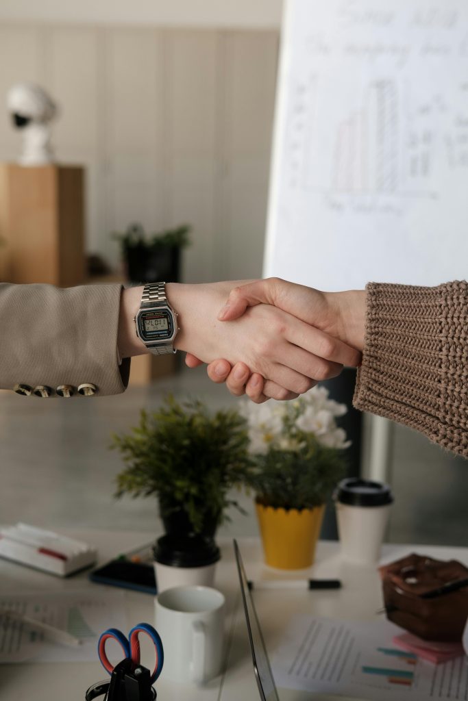 Close-up of a professional handshake between two adults in a contemporary office environment.
